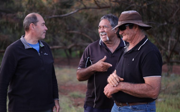 Community members talking together in the field