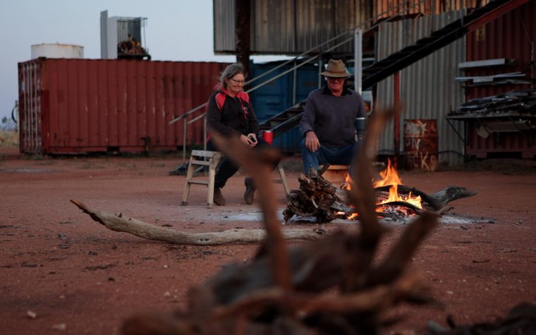 People gathered around a campfire on a station